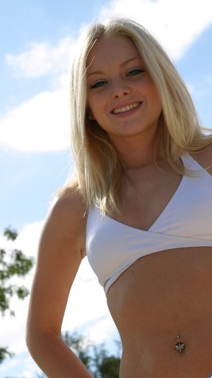 18 year old girl Katie Lewis stands naked after undressing in her bedroom